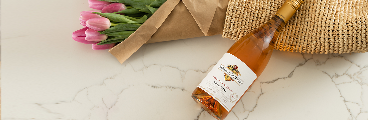 Close up of Kendall-Jackson Vintner's Reserve Rosé with a bouquet of pink tulips.